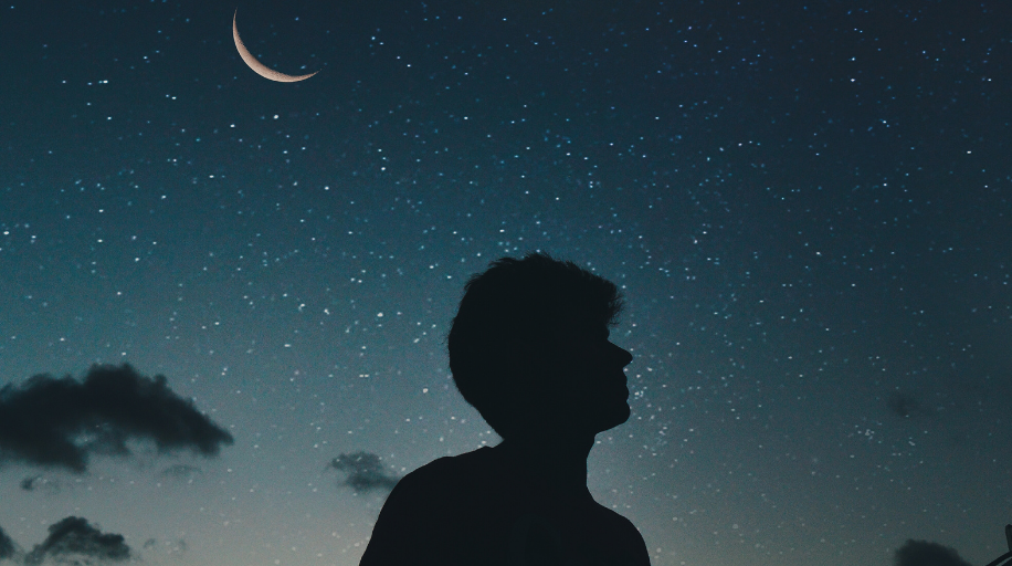 Silhouette of a man looks up at the night sky
